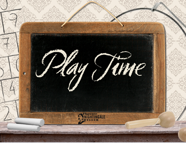 A wooden writing slate with the words 'Play Time' written in chalk in cursive handwriting, a ball and cup toy is at the side